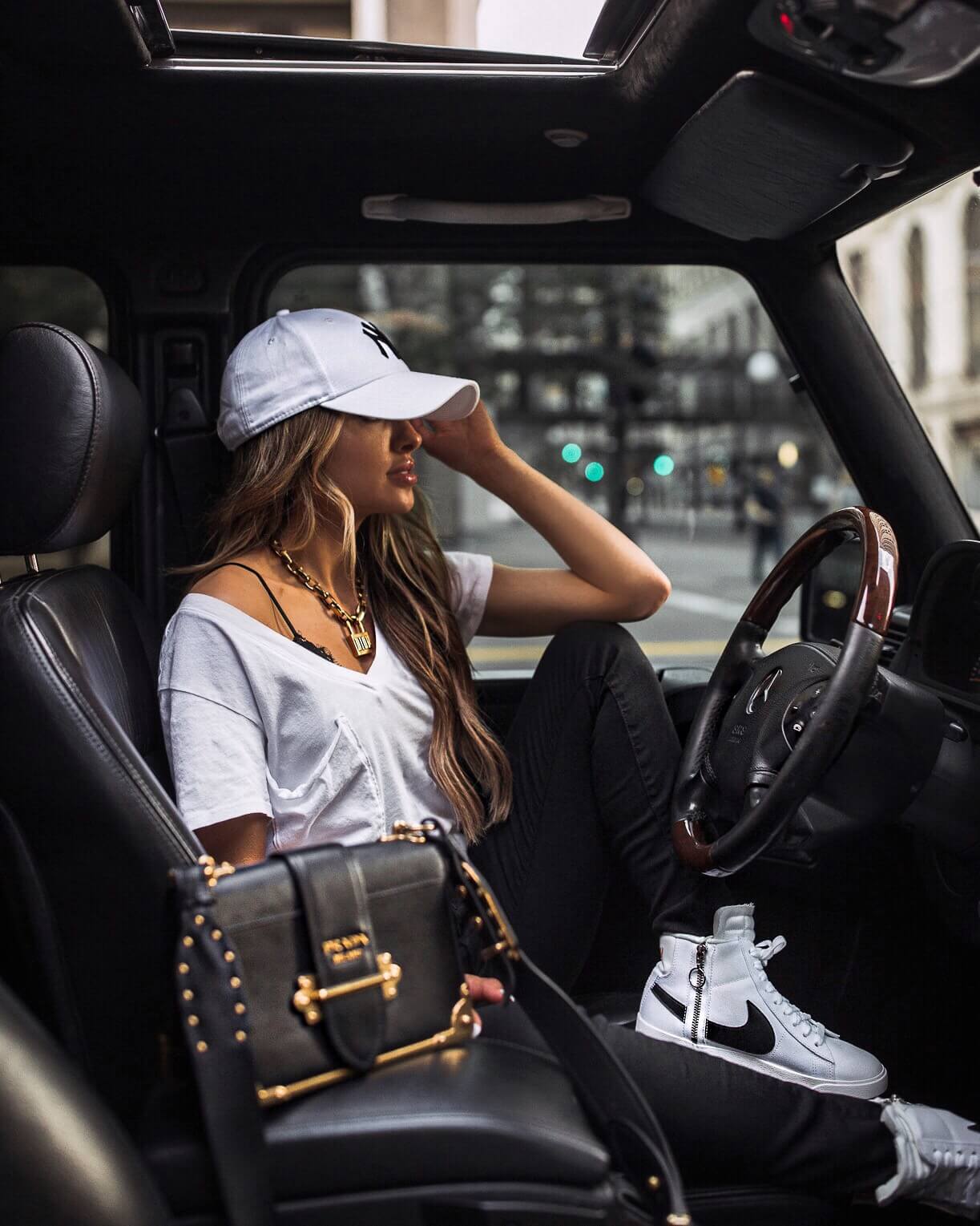 fashion blogger mia mia mine wearing prada cahier bag and a ny yankees hat